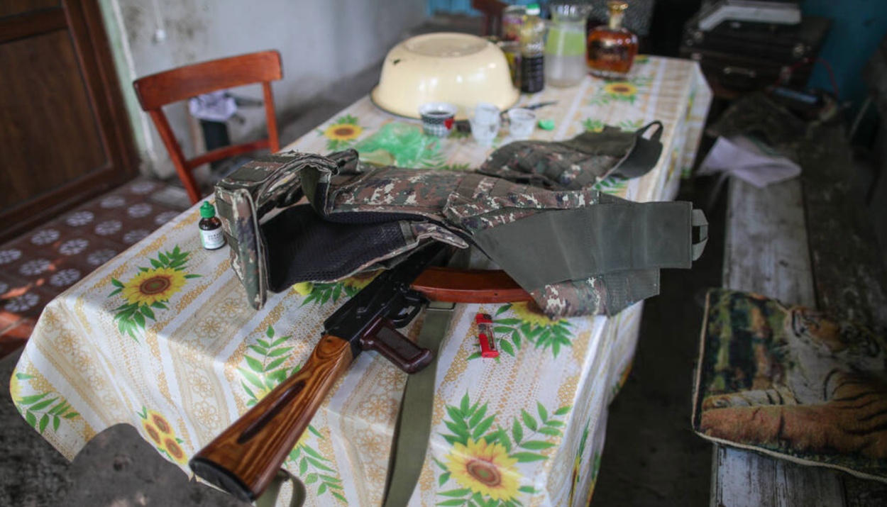 A bulletproof vest and an assault rifle are on the table in the yard of a house in Karabakh. | ©️TASS A bulletproof vest and an assault rifle are on the table in the yard of a house in Karabakh.