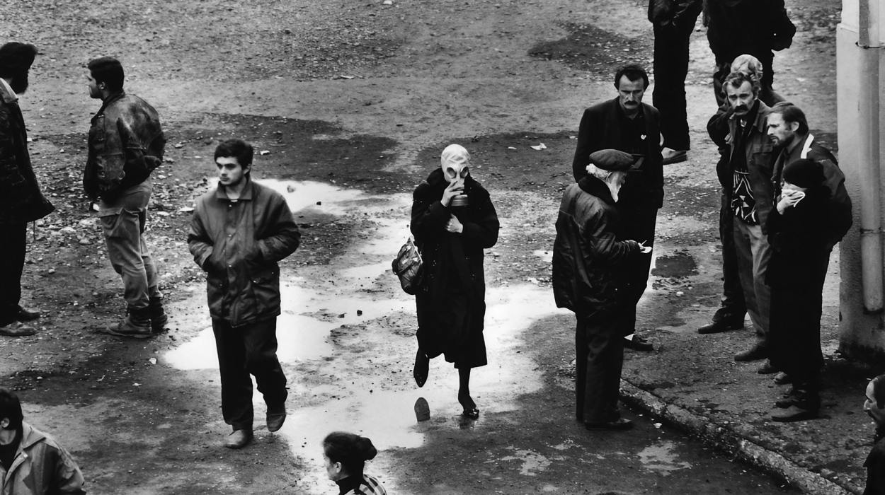 The reburial of around 120 Abkhaz soldiers. A woman wearing a gas mask because of the smell. 1993. The reburial of around 120 Abkhaz soldiers. A woman wearing a gas mask because of the smell. 1993.