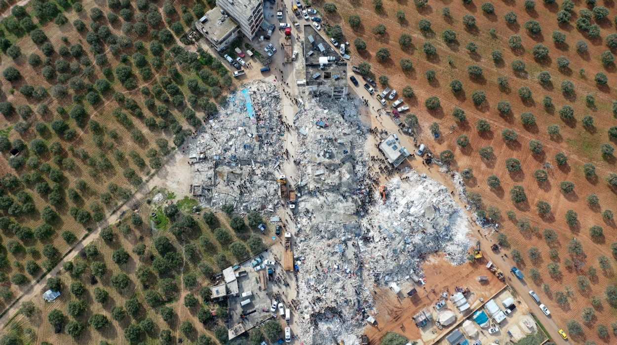 An aerial view of residents searching for victims and survivors amidst the rubble of collapsed buildings in the village of Besnia, Syria. AFP