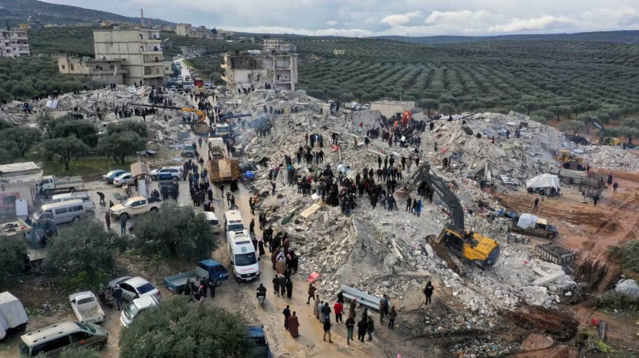 Civil-defense workers and residents search for survivors in the rubble of collapsed buildings in Harem, Syria.